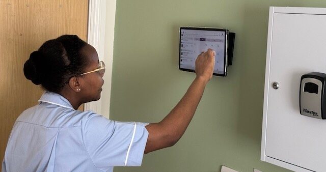 Twinglobes carer using the tablet in a room